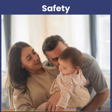 Two parents hold and look at their infant daughter.